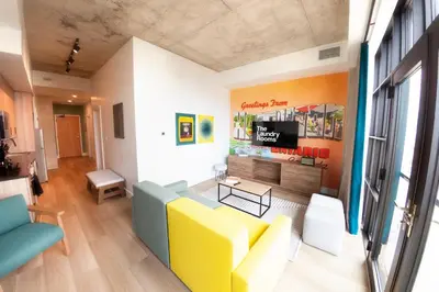 a living room with a yellow couch and a tv at The Laundry Rooms Augusta in Hamilton