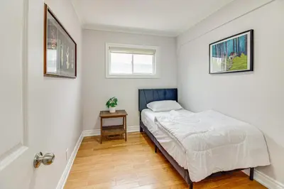 a small bedroom with a bed and a table at Beautiful house near bluffers beach, 25 minutes to Toronto Downtown, free parking, and wifi in Toronto
