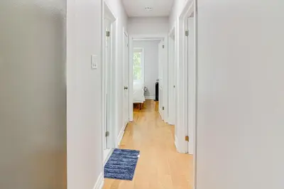 a hallway with white walls and a blue rug at Beautiful house near bluffers beach, 25 minutes to Toronto Downtown, free parking, and wifi in Toronto