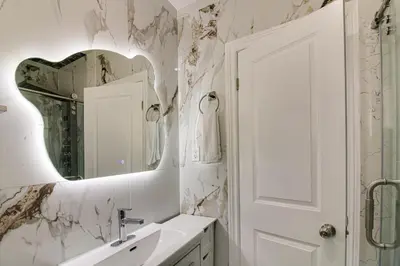a white bathroom with a sink and a mirror at Beautiful house near bluffers beach, 25 minutes to Toronto Downtown, free parking, and wifi in Toronto