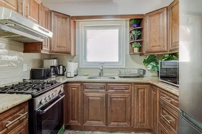 a kitchen with wooden cabinets and a sink and a window at Beautiful house near bluffers beach, 25 minutes to Toronto Downtown, free parking, and wifi in Toronto