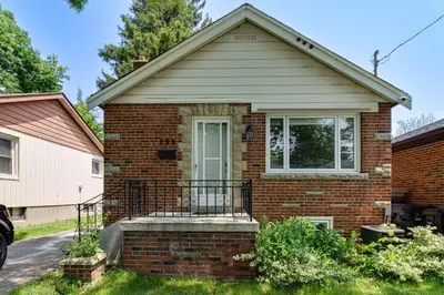 a brick house with a door and a balcony at Beautiful house near bluffers beach, 25 minutes to Toronto Downtown, free parking, and wifi in Toronto