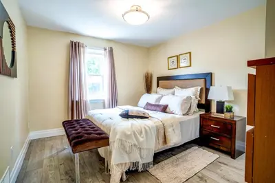 a bedroom with a bed and a table and a window at 2 Bedroom East-York bungalow in Toronto