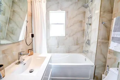 a bathroom with a tub and a sink and a shower at 2 Bedroom East-York bungalow in Toronto
