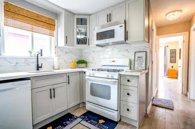 a kitchen with white cabinets and a stove top oven at 2 Bedroom East-York bungalow in Toronto