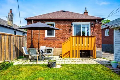 a patio with a table and an umbrella at 2 Bedroom East-York bungalow in Toronto