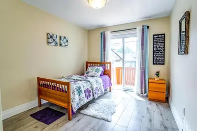 a bedroom with a bed and a sliding glass door at 2 Bedroom East-York bungalow in Toronto