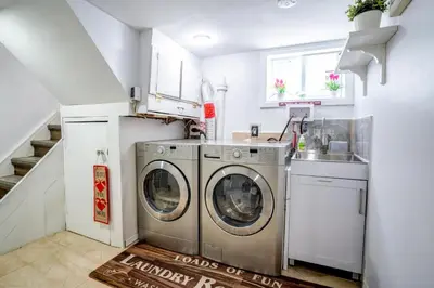 a laundry room with two washing machines and a sink at 2 bedroom + Bath in Eastyork in Toronto