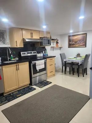 a kitchen with a stove and a table with chairs at 2 bedroom + Bath in Eastyork in Toronto