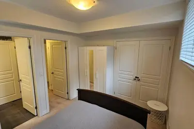 a bedroom with white doors and a bed in a room at Modern 2BR Townhouse w Patio & Free Parking Family & Work Stays in Toronto