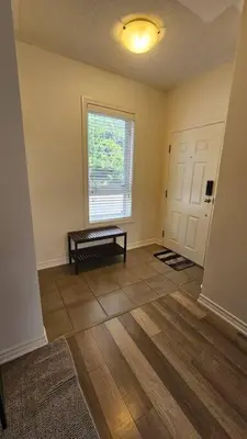 an empty living room with a table and a window at Modern 2BR Townhouse w Patio & Free Parking Family & Work Stays in Toronto