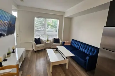 a living room with a blue couch and chairs at Modern 2BR Townhouse w Patio & Free Parking Family & Work Stays in Toronto