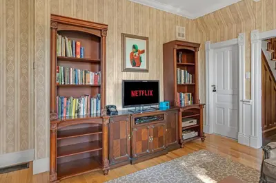 a living room with a tv and book shelves at Hidden Oasis with Hot Tubs, & Starry Fire Pits in Borden