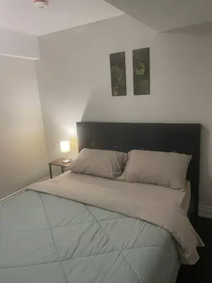 a bedroom with a large bed with two pillows at Zen Nest in Brampton