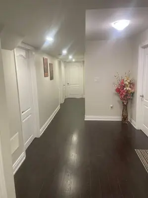 an empty hallway with a vase with flowers in it at Zen Nest in Brampton