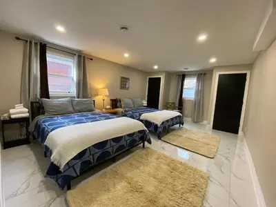 a bedroom with two beds and two rugs at Vacation paradise in St. Catharines