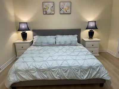 a bedroom with a bed with two night stands at Two-bedroom Suite with King Bed-4 Minutes to The Falls in Niagara Falls
