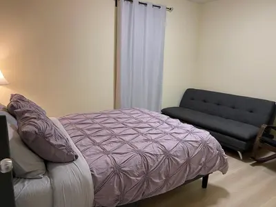 a bedroom with a bed and a couch at Two-bedroom Suite with King Bed-4 Minutes to The Falls in Niagara Falls