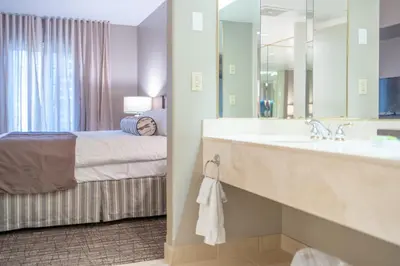 a bathroom with a bed and a sink and a mirror at Horseshoe Valley Suites - The Azure in Shanty Bay