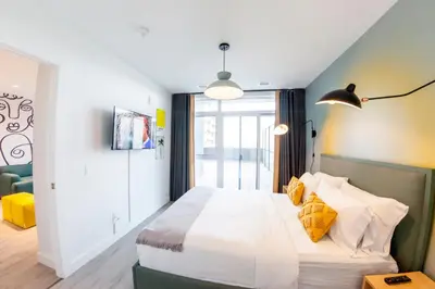 a bedroom with a large bed with yellow pillows at The Laundry Rooms Gaslight Cambridge in Cambridge