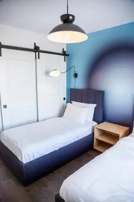 two beds in a room with blue walls at The Laundry Rooms Gaslight Cambridge in Cambridge