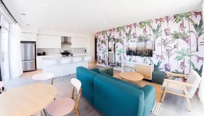 a living room with a blue couch and a kitchen at The Laundry Rooms Gaslight Cambridge in Cambridge