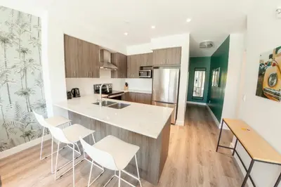 a kitchen with white chairs and a counter top at The Laundry Rooms Gaslight Cambridge in Cambridge