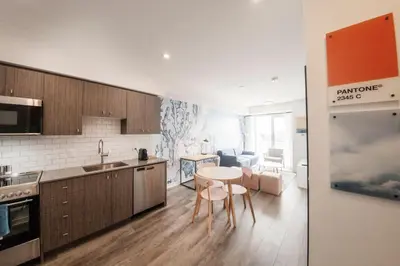 a kitchen with a table and chairs in a room at The Laundry Rooms Station Park Kitchener in Kitchener