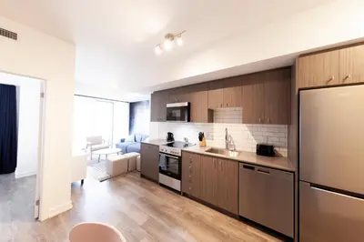 a kitchen with wooden cabinets and stainless steel appliances at The Laundry Rooms Station Park Kitchener in Kitchener