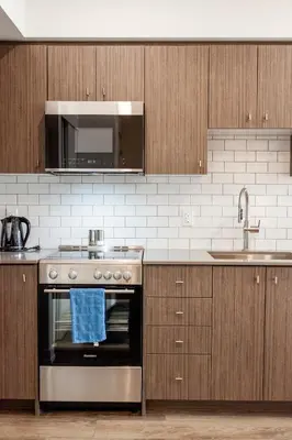 a kitchen with a stainless steel stove and a sink at The Laundry Rooms Station Park Kitchener in Kitchener