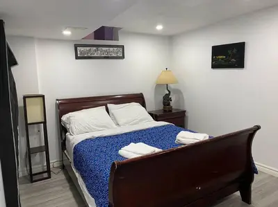 a bedroom with a bed with blue sheets and white pillows at Large Separate Entrance Basement Unit 2Beds 1Washroom Sleeps 4-6 in Pickering