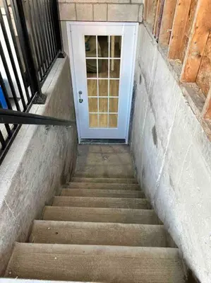 a stairway leading to a white door with a stair at Large Separate Entrance Basement Unit 2Beds 1Washroom Sleeps 4-6 in Pickering