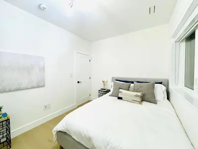 a white bedroom with a bed and a window at Urban 2-bed apartment in the Beaches in Toronto