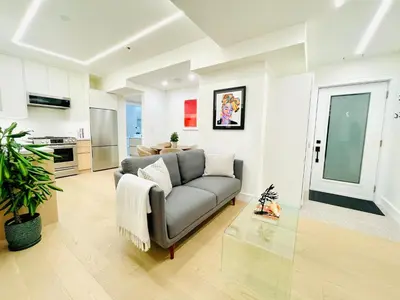 a living room with a couch and a kitchen at Urban 2-bed apartment in the Beaches in Toronto