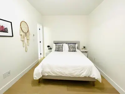 a white bedroom with a large bed in it at Urban 2-bed apartment in the Beaches in Toronto