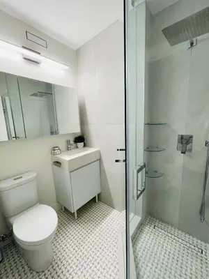 a white bathroom with a toilet and a shower at Urban 2-bed apartment in the Beaches in Toronto