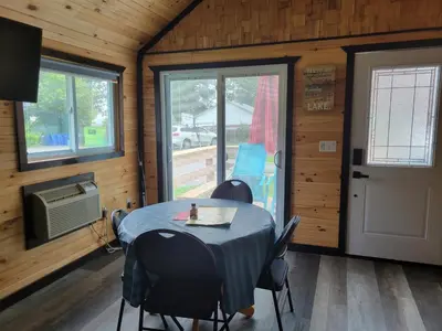 a dining room with a table and chairs in a cabin at Stoneburg Cove Cottages in Carrying Place