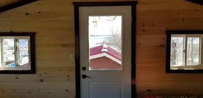 a door in a log house with a window at Stoneburg Cove Cottages in Carrying Place