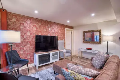 a living room with a couch and a flat screen tv at Rustic Elegant Stays in Niagara Benchlands in Beamsville