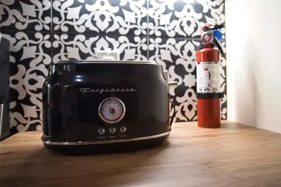 a black toaster sitting on a table next to a bottle at Rustic Elegant Stays in Niagara Benchlands in Beamsville
