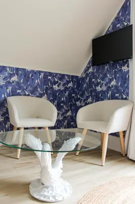 a living room with two chairs and a glass table at Queen Suite with Private Ensuite at Fancie's PEC - Suite 1 in Belleville