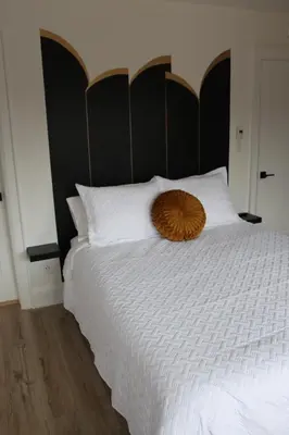 a bedroom with a large bed with a wooden headboard at 4 Guest Suite with Waterfront Views at Fancie's PEC - Suite 2 in Belleville