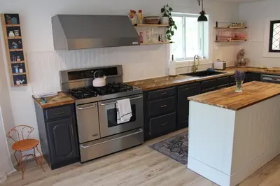 a kitchen with black cabinets and a stove top oven at 4 Guest Suite with Waterfront Views at Fancie's PEC - Suite 2 in Belleville