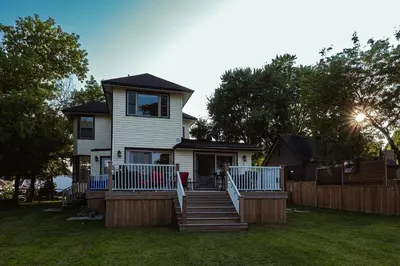 a house with a porch and stairs in the yard at Luxurious Lakeview Oasis in the Heart of Hamilton With Large Backyard in Hamilton