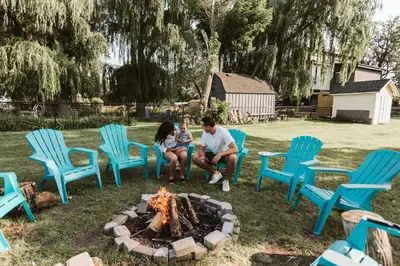 a man and woman sitting around a fire in a yard at Luxurious Lakeview Oasis in the Heart of Hamilton With Large Backyard in Hamilton