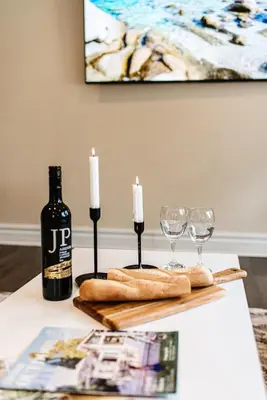 a table with a bottle of wine and two wine glasses at Luxurious Lakeview Oasis in the Heart of Hamilton With Large Backyard in Hamilton