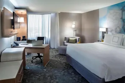 a hotel room with a large bed and a desk at Courtyard by Marriott Toronto Northeast/Markham in Markham