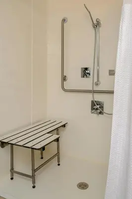 a bathroom with a bench and a shower at Courtyard by Marriott Toronto Northeast/Markham in Markham
