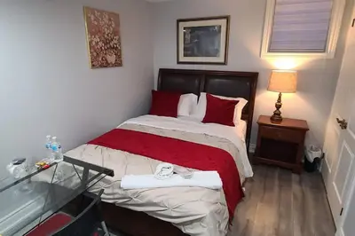 a small bedroom with a bed with red pillows at LUXURY 2-BEDROOMS UNIT WITH WIFI, LDR & PARKING. in Cambridge