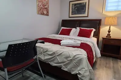 a bedroom with a bed and a desk and a chair at LUXURY 2-BEDROOMS UNIT WITH WIFI, LDR & PARKING. in Cambridge